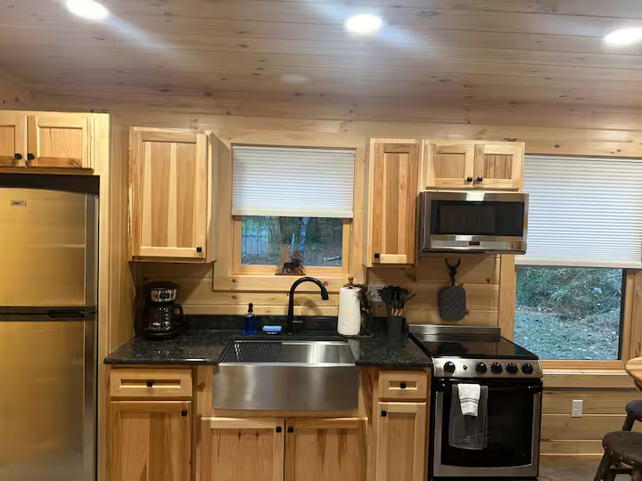 Full kitchen with stainless steel appliances inside Swiftwater cabin
